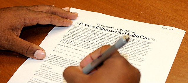 A person signing a document with a registered agent stamp.