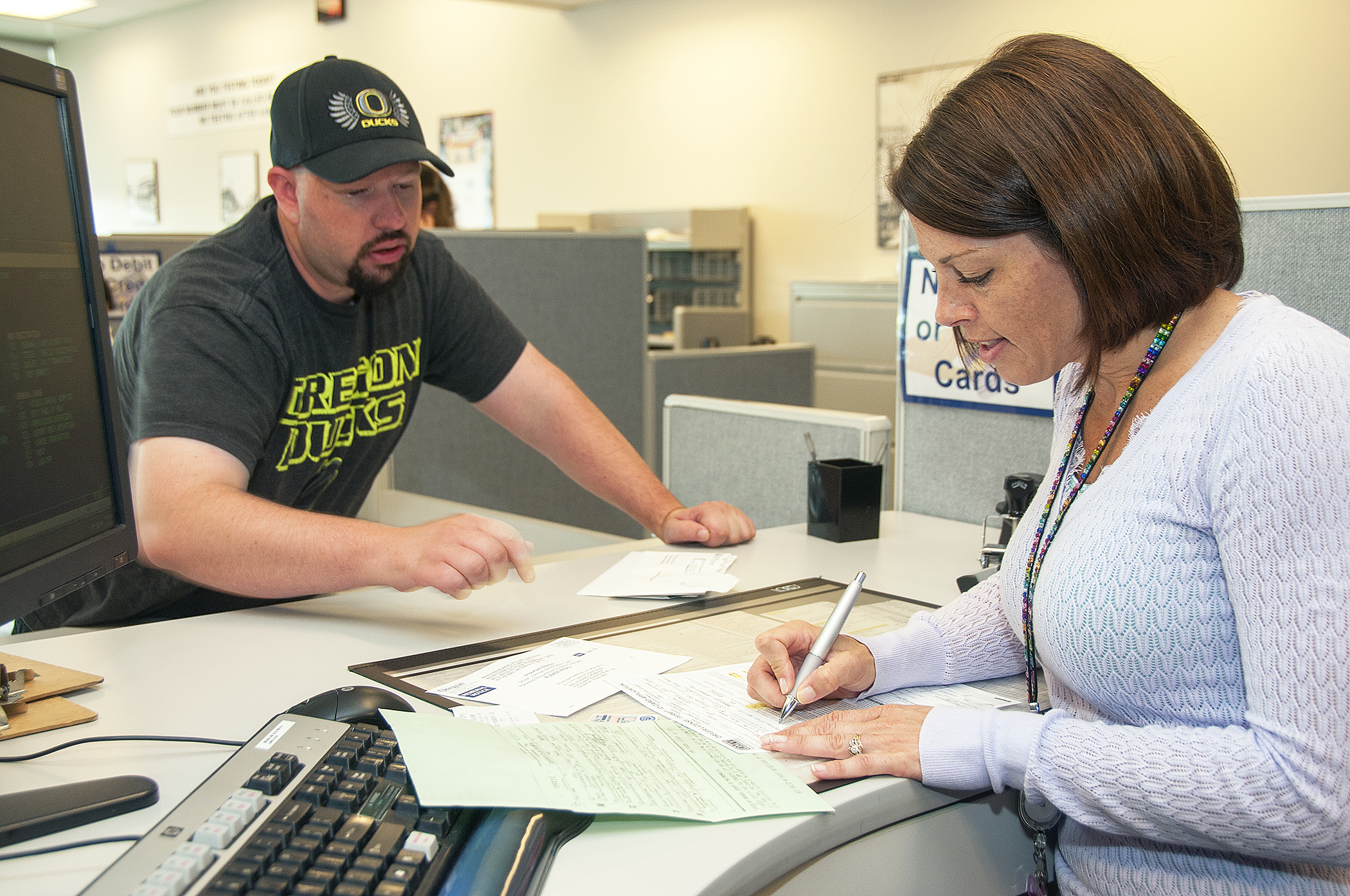 A professional agent assisting a client with paperwork.