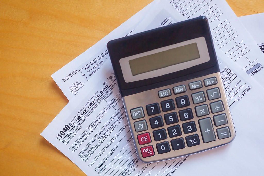 An image depicting a corporate tax form or a calculator with dollar signs.